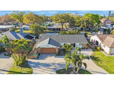 An inviting single-story home featuring manicured landscaping and a patterned brick driveway at 22 Oak Ave, Palm Harbor, FL 34684