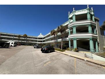 A view of the exterior with palm trees and parking available in front of the condo building on a sunny day at 2370 Jamaican St # 46, Clearwater, FL 33763