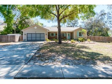 Charming single-story home with a well-maintained lawn, mature tree, and a two-car garage at 275 S Highland Ave, Tarpon Springs, FL 34689