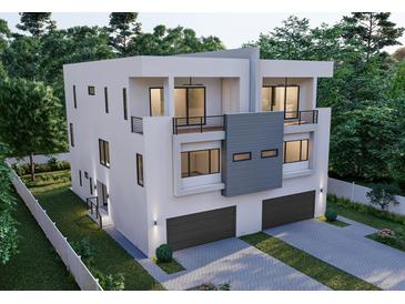 Contemporary three-story home with a modern design, dual balconies, and a two-car garage, set amongst mature trees at 4509 W North A St # 1, Tampa, FL 33609