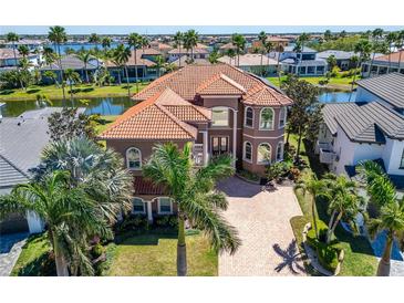 Stunning front exterior featuring a tile roof, manicured lawn, and mature landscaping at 1408 Alhambra Dr, Apollo Beach, FL 33572