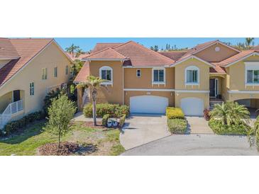 Charming home featuring a two-car garage, a red tile roof, and well manicured landscaping at 16 Franklin S Ct # A, St Petersburg, FL 33711