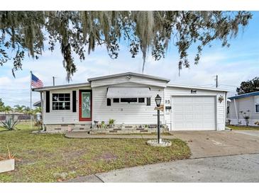 Charming single-story home featuring a tidy front yard, garage, and classic white exterior at 1710 7Th Sw St # 95, Ruskin, FL 33570