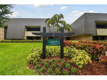 Well-maintained condo complex featuring mature landscaping and an inviting entrance sign at 36750 Us 19 N # 08102, Palm Harbor, FL 34684