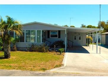 Charming single-story home with a covered carport and well-maintained landscaping at 5546 Benton St, Zephyrhills, FL 33542