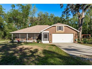 Charming single-story home with a well-maintained lawn, screened in porch and an attached two car garage at 7182 Griffin Rd, Brooksville, FL 34601