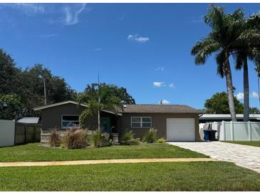Charming single-story home with a well-maintained lawn, mature trees, and a driveway leading to a one-car garage at 1836 Bayou Grande Ne Blvd, St Petersburg, FL 33703