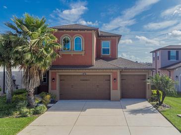Charming two-story home featuring a three-car garage, neutral color palette, and meticulously maintained landscaping at 28923 Lucero Ln, Wesley Chapel, FL 33543