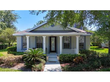 Charming single-story home featuring a welcoming front porch with white columns and lush landscaping at 6002 Churchside Dr, Lithia, FL 33547