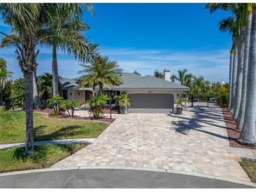 Beautiful single-story home featuring a paver driveway, lush landscaping, and an attached two-car garage at 6614 Blackfin Way, Apollo Beach, FL 33572