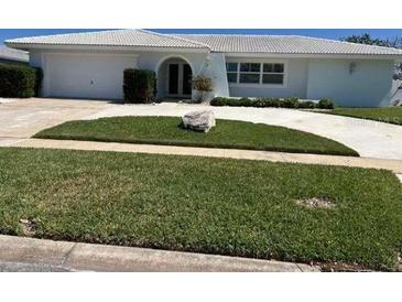 Well-manicured lawn and landscaping enhance the curb appeal of this single story home at 731 Snug Is, Clearwater, FL 33767