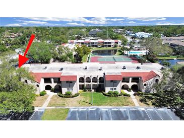 Attractive condo building with red tile roof, manicured landscaping, and ample parking at 9700 Starkey Rd # 321, Seminole, FL 33777