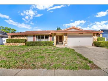 Charming single-story home with stone accents, well-maintained landscaping, and an attached two-car garage at 10014 118Th Way, Seminole, FL 33772