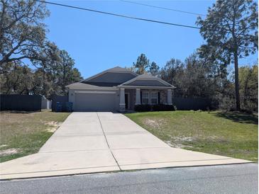 Charming single-story home with a well-manicured lawn and a two-car garage at 10240 Meadow Wren Ave, Weeki Wachee, FL 34613