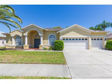 Charming single-story home featuring a well-maintained lawn and a three-car garage at 1422 Distant Oaks Dr, Wesley Chapel, FL 33543