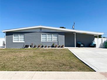 A cozy single-story home featuring a gray exterior, white trim, and a well-manicured lawn at 21298 Austin Ave, Port Charlotte, FL 33952