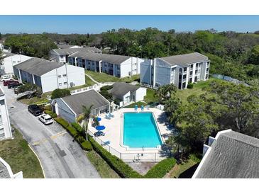 A clean community pool is surrounded by well-maintained landscaping and condominium buildings at 2625 State Road 590 # 2613, Clearwater, FL 33759