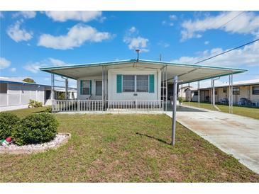 Charming mobile home with a well-maintained lawn and covered carport in a peaceful community at 5306 Mary St, Zephyrhills, FL 33542