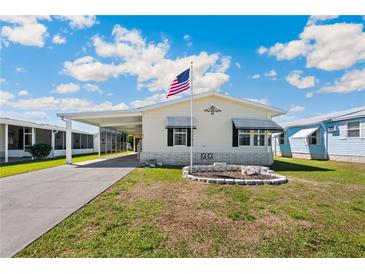 Charming single-story home featuring a carport, manicured lawn, and decorative stonework at 5745 Pawnee St, Zephyrhills, FL 33542