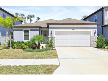 Charming single-Gathering home with a manicured lawn, two-car garage, and welcoming entryway at 14180 Samoa Hill Ct, Riverview, FL 33569