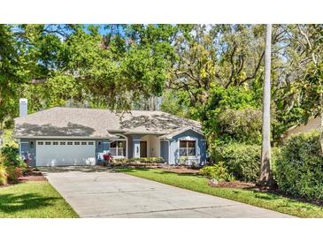 Charming single-story home with well-manicured lawn, mature trees, and a two-car garage at 3267 Westcott Ct, Palm Harbor, FL 34684