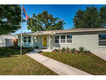 Charming single-story home with a bright yellow door and well-maintained landscaping at 6460 17Th N Ln, St Petersburg, FL 33702