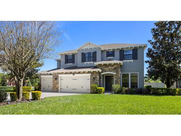 Charming two-story home featuring a stone facade and a manicured front yard with mature landscaping at 17909 Howsmoor Pl, Lutz, FL 33559