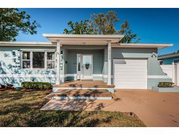 Charming single-story home featuring a covered porch, light blue paint, and a well-maintained front lawn at 2736 45Th N Way, St Petersburg, FL 33713