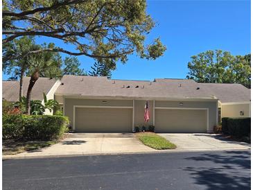 Charming two-story home featuring a two-car garage, well-maintained landscaping, and a welcoming American flag at 3186 Eagles Landing W Cir, Clearwater, FL 33761