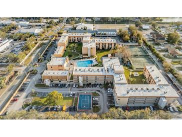 An aerial view of the condo complex with swimming pool, tennis courts, and ample parking at 5820 N Church Ave # 148, Tampa, FL 33614