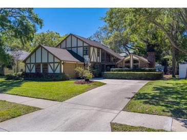 Charming two-story Tudor-style home with lush lawn and mature trees at 1439 Wetherington Way, Palm Harbor, FL 34683