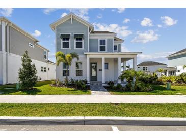 Charming two-story home features a welcoming porch, landscaped yard, and light blue accents at 1558 Merrythought Ln, Sarasota, FL 34240