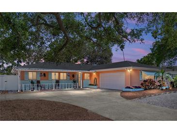 Charming single-story home with manicured lawn, mature trees, and spacious driveway at 1763 Bayshore Blvd, Dunedin, FL 34698