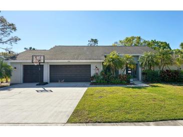 Charming single-story home with a well-maintained lawn, mature landscaping, and a spacious driveway leading to a two-car garage at 3994 Belmoor Dr, Palm Harbor, FL 34685