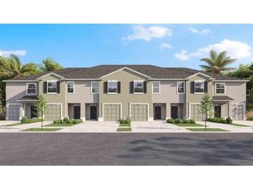 New townhouse exterior showcases garages, black door, dark shutters, light landscaping, and a modern design at 228 Royal Spoonbill Dr, Ruskin, FL 33570