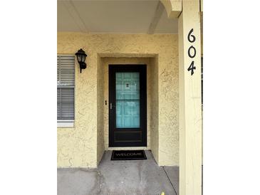Inviting front door entrance with black-trimmed glass door, textured walls, and visible unit number at 2465 Northside Dr # 604, Clearwater, FL 33761