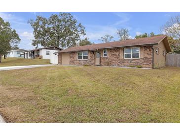 Charming brick home featuring a well-maintained front lawn and inviting curb appeal at 27103 Frampton Ave Ave, Brooksville, FL 34602