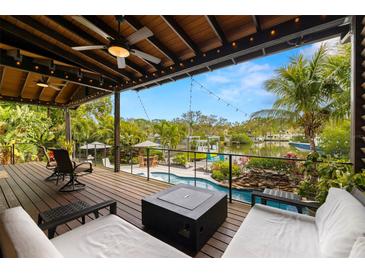 Spacious outdoor deck overlooking a canal with lush landscaping and a resort style pool at 4806 W San Rafael St, Tampa, FL 33629