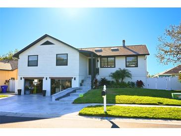 Beautiful two-story home featuring an open garage, well-manicured lawn, and driveway at 4954 Cardinal Trl, Palm Harbor, FL 34683