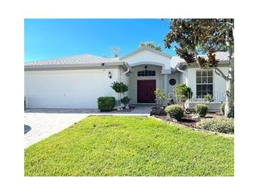 Charming single-story home with a well-manicured lawn, mature trees and a double door entrance at 14305 Tennyson Dr, Hudson, FL 34667