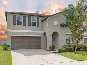 Charming two-story home featuring a well-maintained front yard and a two-car garage at 5210 Dandelion St, Apollo Beach, FL 33572