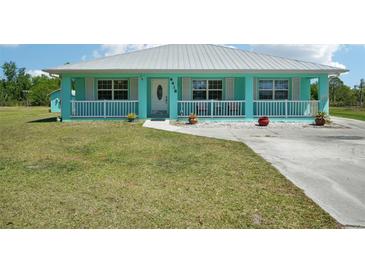 Charming turquoise home with white trim, metal roof, and a cozy front porch at 6418 Austrian Blvd, Punta Gorda, FL 33982