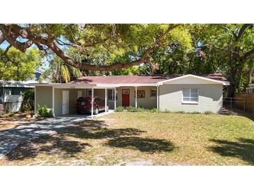 Charming single-story home with a covered carport and well-maintained lawn and mature trees at 7303 N Branch Ave, Tampa, FL 33604