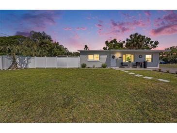 Charming home with a well-manicured lawn and a white fence, creating a welcoming and private outdoor space at 7401 35Th N Ave, St Petersburg, FL 33710