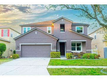 Charming two-story home boasts a manicured lawn, a two-car garage, and fresh landscaping at 11118 Golden Silence Dr, Riverview, FL 33579