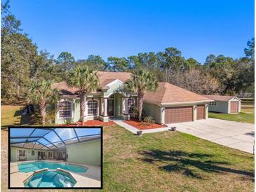 Inviting exterior of home with a pool, three-car garage, well-kept lawn, and palm tree accents at 16340 Marquis Rd, Brooksville, FL 34614