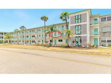 Inviting condo building featuring charming turquoise accents and lush palm trees, offering a serene coastal living experience at 1900 59Th N Ave # 217, St Petersburg, FL 33714