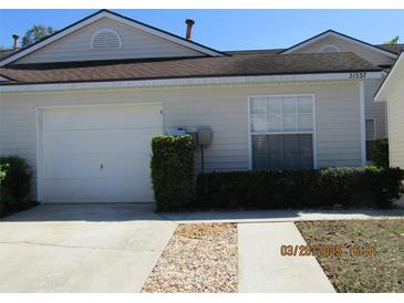 Charming one-story home featuring a one-car garage and tidy landscaping at 21537 Clubside Loop, Lutz, FL 33549