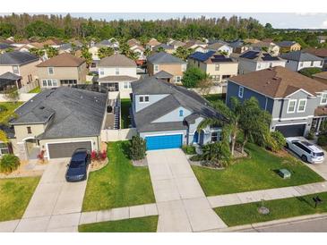 Wonderful home with a bright blue garage door nestled in a neighborhood with mature trees and well-kept lawns at 1571 Montgomery Bell Rd, Wesley Chapel, FL 33543