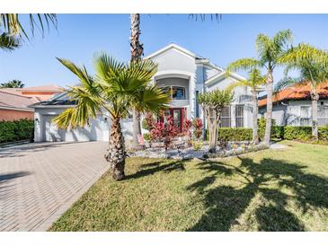 Beautiful two-story home featuring tropical landscaping and a brick-paved driveway at 17927 Bahama Isle Cir, Tampa, FL 33647